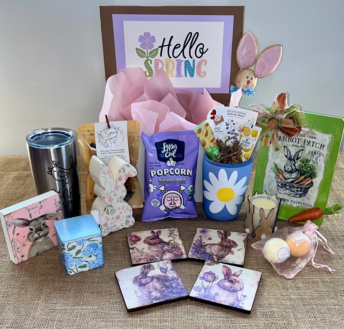 A collection of Easter-themed items including a bunny-themed popcorn bucket, chocolate eggs, a framed 'Happy Easter' sign, and other assorted Easter treats.