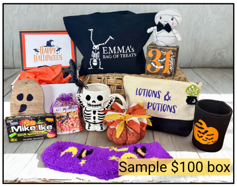 Halloween-themed gift box with various items including a mug, pillow, and candy on a wooden surface.