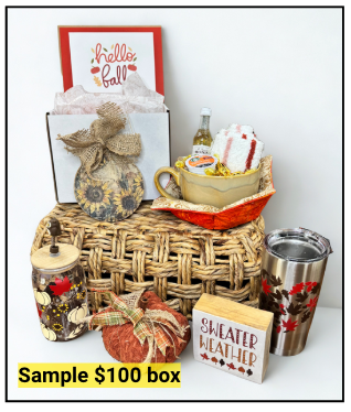 Gift basket with fall-themed items including a mug, tumbler, and decorative pumpkins on a white background.