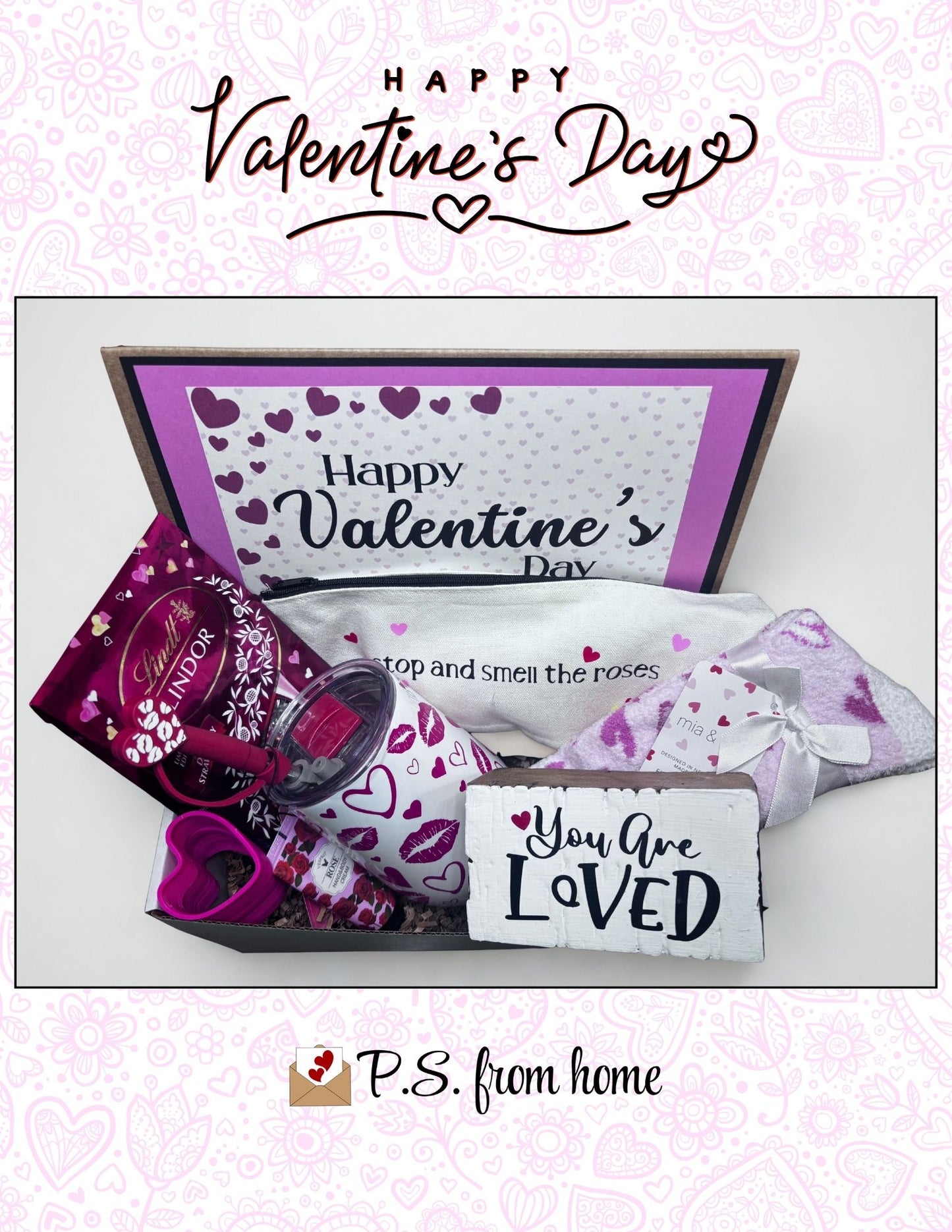 Valentine's Day gift box with chocolates, candy, and a card on a light pink background.